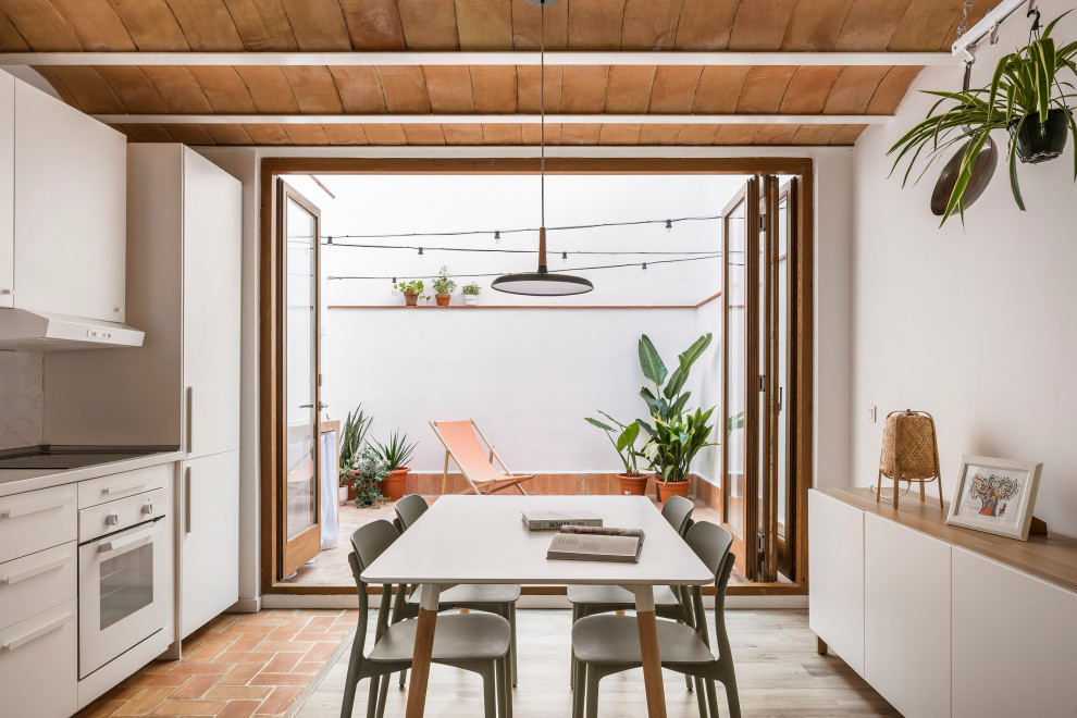 Идея дизайна: маленькая гостиная-столовая в средиземноморском стиле с белыми стенами, полом из ламината, коричневым полом и балками на потолке для на участке и в саду