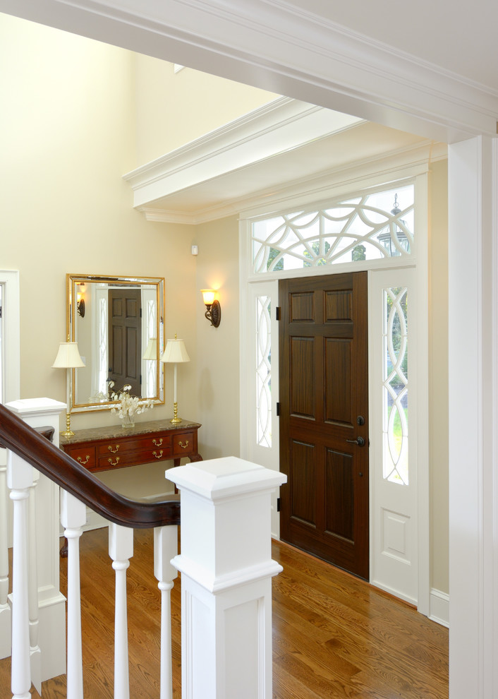 Inspiration for a mid-sized traditional foyer in Boston with beige walls, medium hardwood floors, a single front door and a dark wood front door.