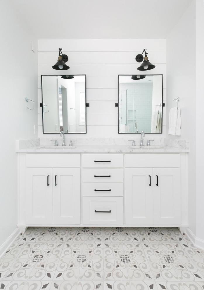 Mid-sized country master bathroom in Charleston with white cabinets, a freestanding tub, white tile, ceramic tile, white walls, cement tiles, an undermount sink, grey floor and a hinged shower door.