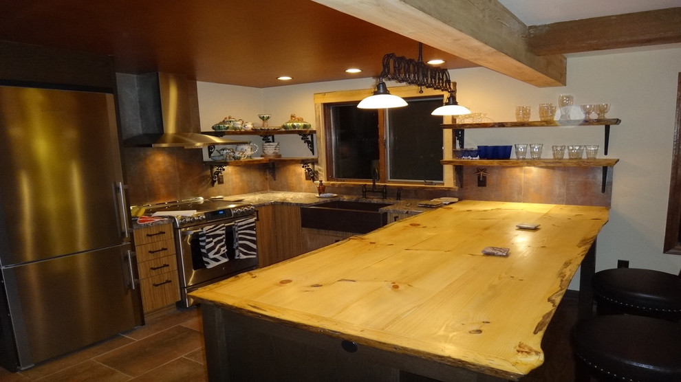Mid-sized mountain style kitchen photo with medium tone wood cabinets, wood countertops, metallic backsplash and an island