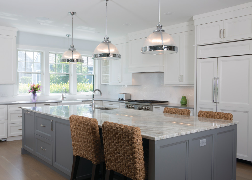 Large transitional l-shaped medium tone wood floor and brown floor open concept kitchen photo in Boston with a farmhouse sink, shaker cabinets, white cabinets, granite countertops, white backsplash, stainless steel appliances and an island