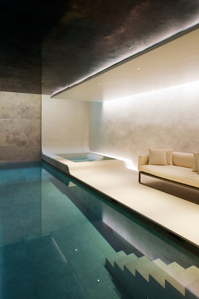 Large modern indoor rectangular lap pool in London with a hot tub.