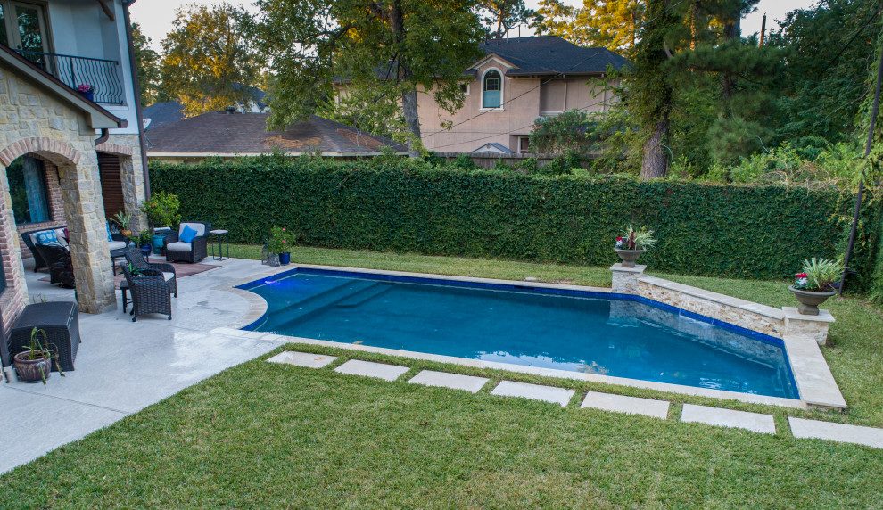 Photo of a small traditional backyard custom-shaped pool in Houston with natural stone pavers.