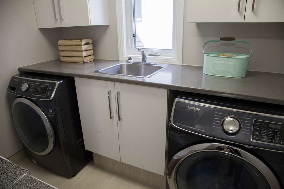 Inspiration for a small transitional single-wall porcelain tile utility room remodel in Edmonton with a drop-in sink, flat-panel cabinets, white cabinets, laminate countertops, gray walls, a side-by-side washer/dryer and gray countertops