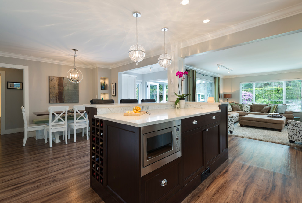 Mid-sized transitional l-shaped medium tone wood floor open concept kitchen photo in Vancouver with an undermount sink, shaker cabinets, white cabinets, quartz countertops, white backsplash, stone tile backsplash, stainless steel appliances and an island