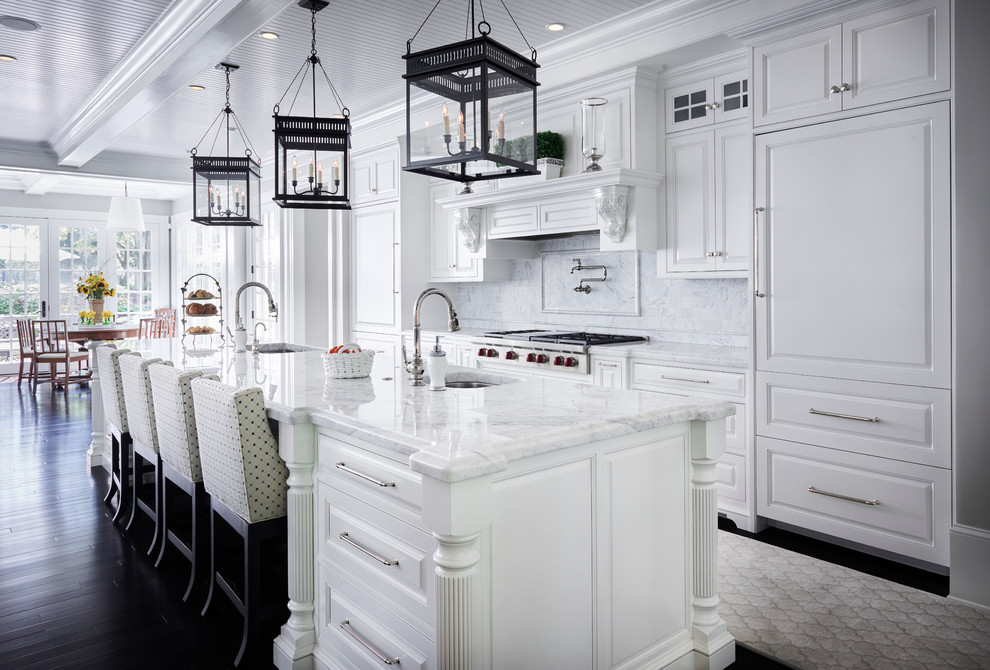Inspiration for an expansive traditional galley eat-in kitchen in Philadelphia with white cabinets, granite benchtops, white splashback, ceramic splashback, white appliances, dark hardwood floors, with island, an undermount sink and raised-panel cabinets.
