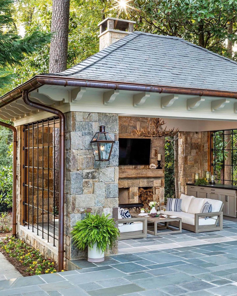 Immagine di un grande patio o portico chic dietro casa con un caminetto, pavimentazioni in pietra naturale e un gazebo o capanno