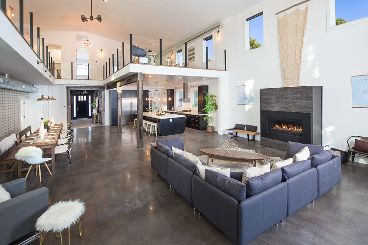 Inspiration for an expansive industrial formal open concept living room in San Francisco with white walls, concrete floors, a ribbon fireplace, a metal fireplace surround and no tv.