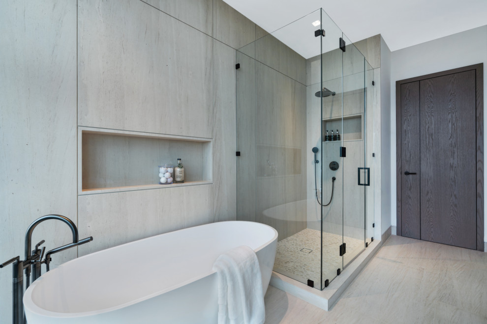 На фото: ванная комната в современном стиле с отдельно стоящей ванной, угловым душем, бежевой плиткой, плиткой из известняка, полом из известняка и душем с распашными дверями с