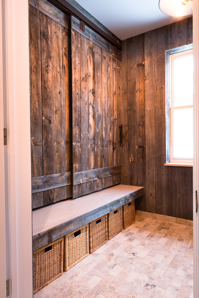 Inspiration for a mid-sized country mudroom in Denver with travertine floors, brown walls and beige floor.