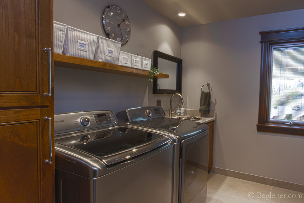 Inspiration for a small transitional galley dedicated laundry room in Other with an undermount sink, raised-panel cabinets, medium wood cabinets, granite benchtops, grey walls, marble floors and a side-by-side washer and dryer.