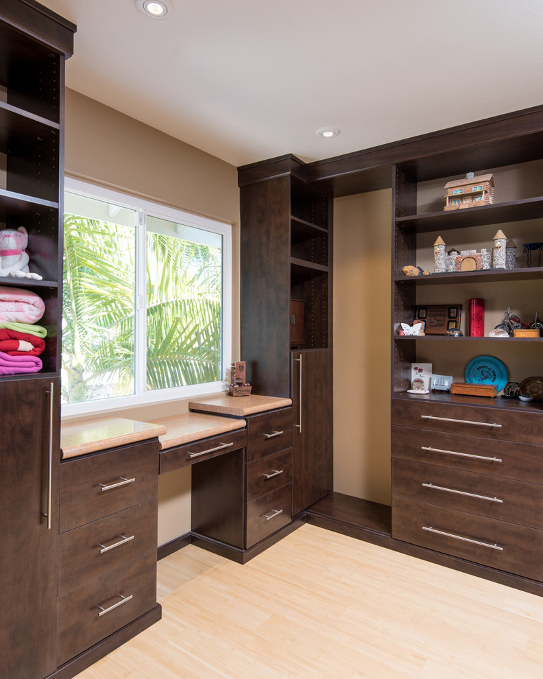 Expansive asian gender-neutral walk-in wardrobe in San Diego with shaker cabinets, dark wood cabinets and light hardwood floors.