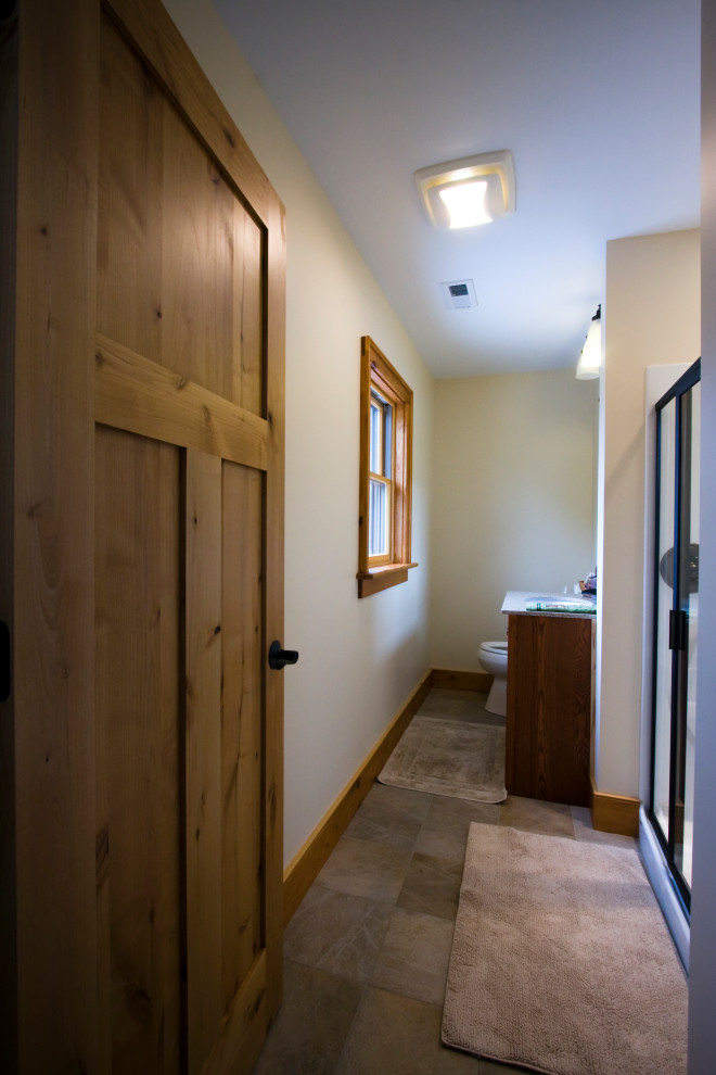 Claw-foot bathtub - mid-sized master brown tile and ceramic tile ceramic tile and single-sink claw-foot bathtub idea with brown cabinets, a two-piece toilet, beige walls, an integrated sink, a hinged shower door, white countertops and a built-in vanity