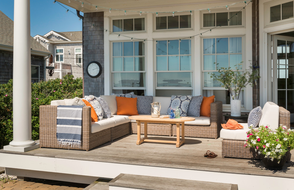 Design ideas for a mid-sized beach style backyard deck in Providence with a roof extension.