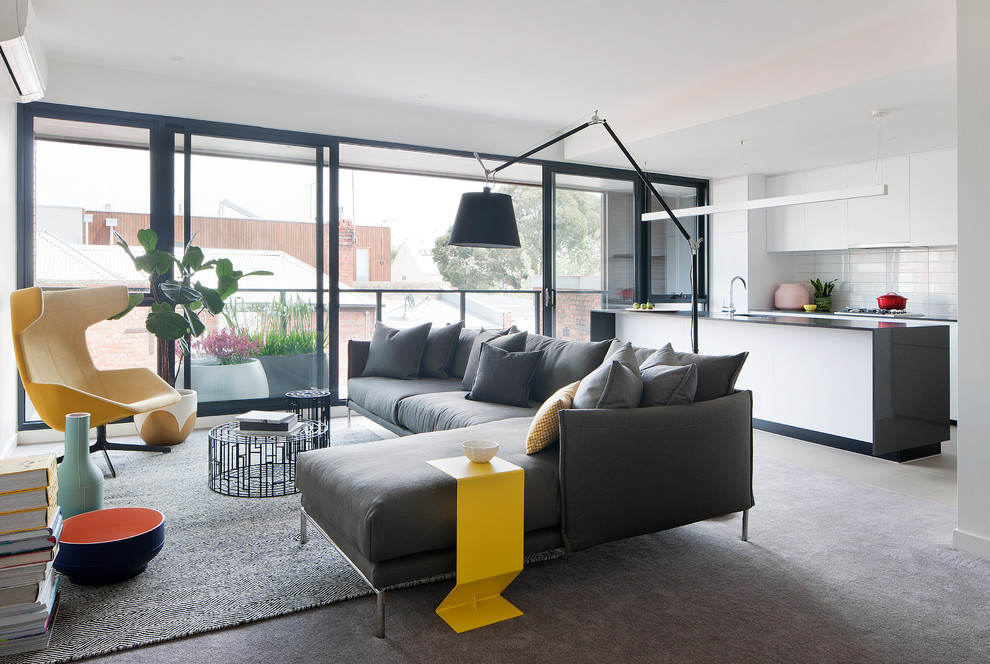 Contemporary living room in Melbourne with white walls and carpet.