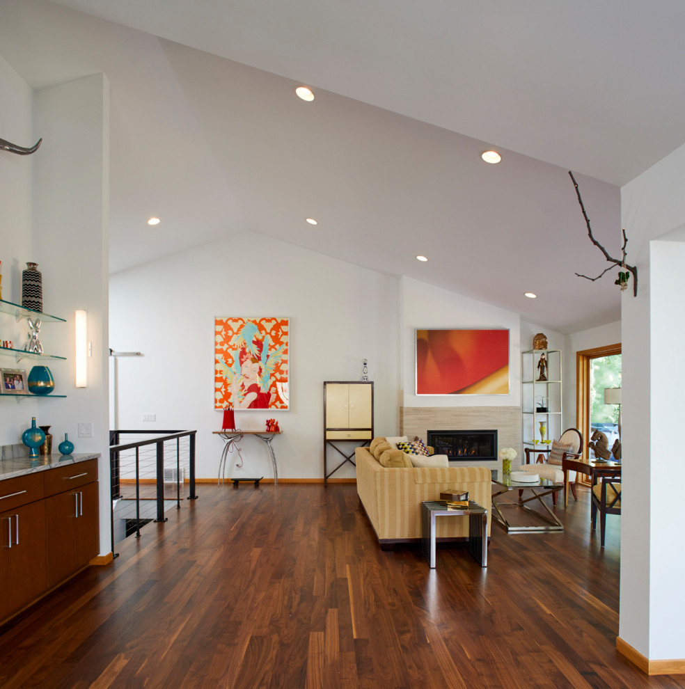 Modernes Wohnzimmer im Loft-Stil mit Hausbar, weißer Wandfarbe, dunklem Holzboden, Kamin, Kaminumrandung aus Stein, braunem Boden und gewölbter Decke in Minneapolis