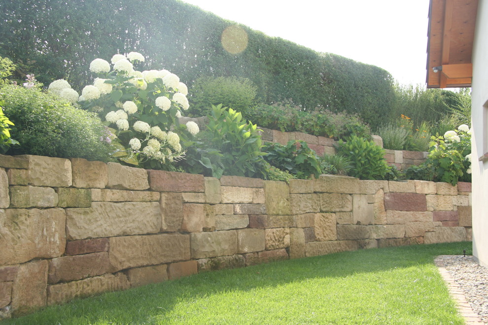 This is an example of a country garden in Stuttgart with a retaining wall.