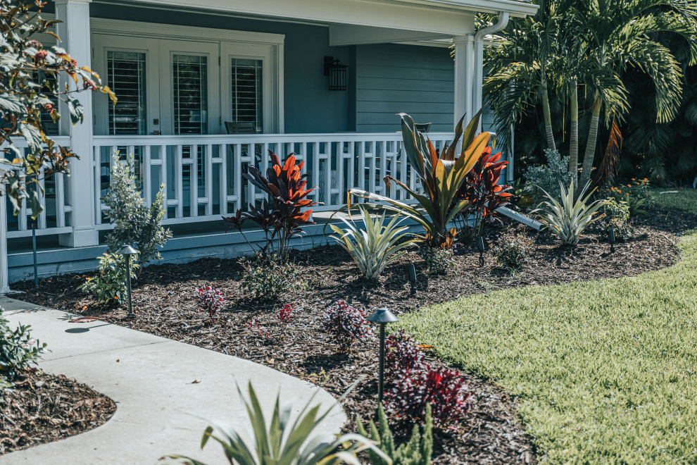 Photo of a tropical front yard garden in Other with with flowerbed.