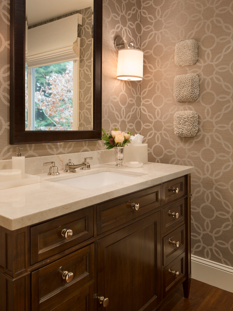 Powder room - mid-sized traditional dark wood floor and brown floor powder room idea in San Francisco with an undermount sink, recessed-panel cabinets, dark wood cabinets, beige walls, marble countertops and beige countertops