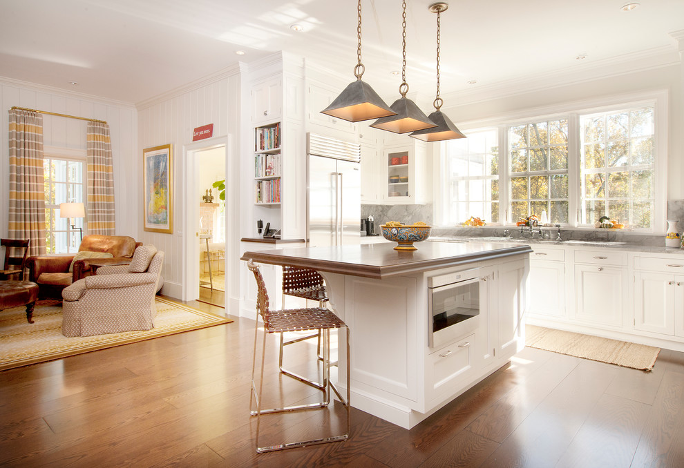 Open concept kitchen - traditional u-shaped dark wood floor open concept kitchen idea in New York with an undermount sink, recessed-panel cabinets, white cabinets, marble countertops, gray backsplash, stainless steel appliances and an island