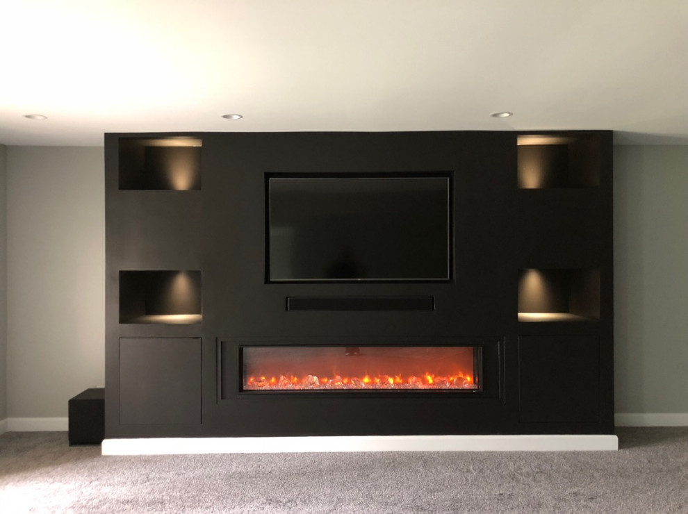 Inspiration for a large modern walk-out basement in Louisville with grey walls, carpet, a hanging fireplace, a plaster fireplace surround and grey floor.