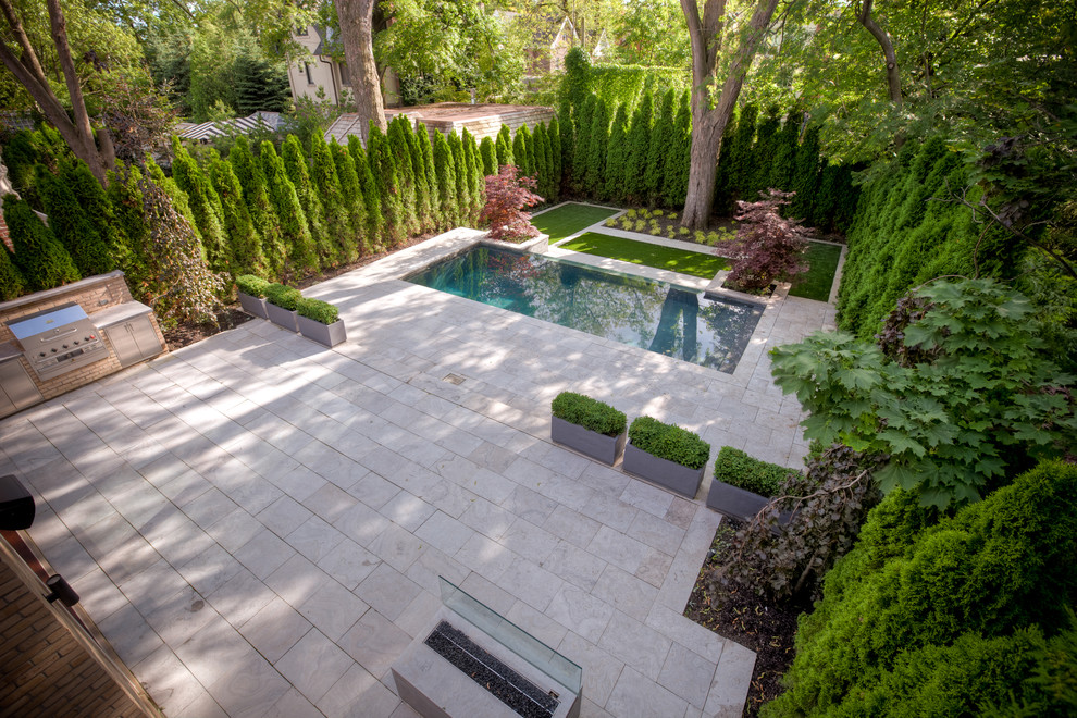 Example of a mid-sized trendy backyard stone patio kitchen design in Toronto with no cover