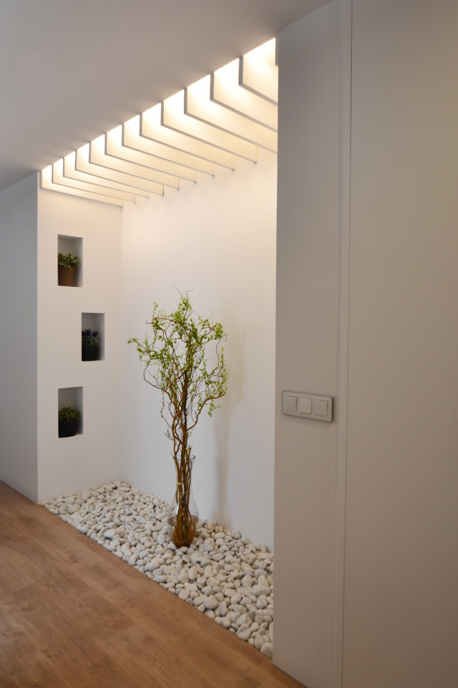 Idéer för mellanstora minimalistiska hallar, med vita väggar, mellanmörkt trägolv och brunt golv