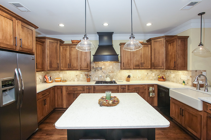 Design ideas for a mid-sized arts and crafts u-shaped eat-in kitchen in Atlanta with a farmhouse sink, shaker cabinets, medium wood cabinets, quartzite benchtops, beige splashback, stone tile splashback, stainless steel appliances, medium hardwood floors and with island.
