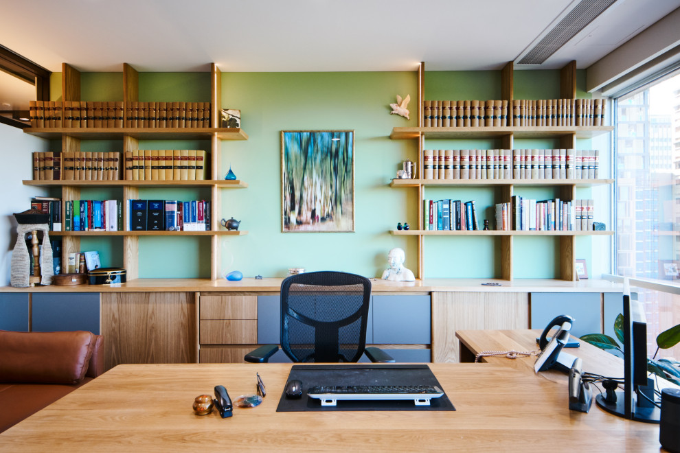 Inspiration för mellanstora moderna hemmabibliotek, med gröna väggar, heltäckningsmatta, ett fristående skrivbord och grått golv