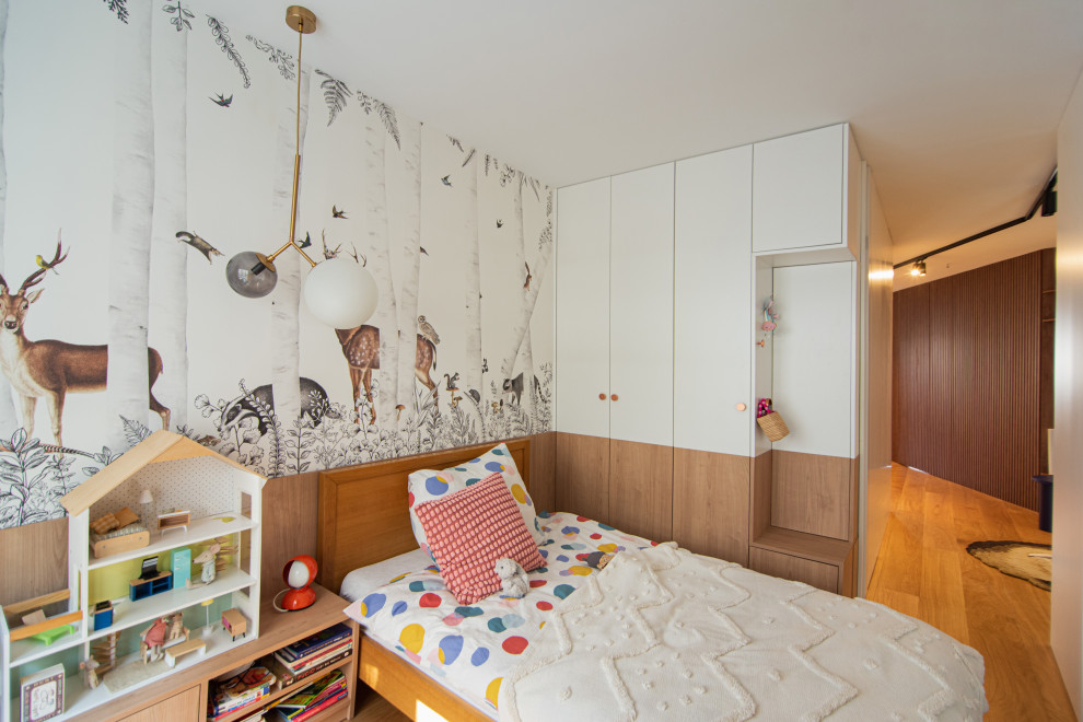 Ispirazione per una cameretta per bambini da 4 a 10 anni moderna di medie dimensioni con pareti bianche, parquet chiaro, pavimento marrone e carta da parati