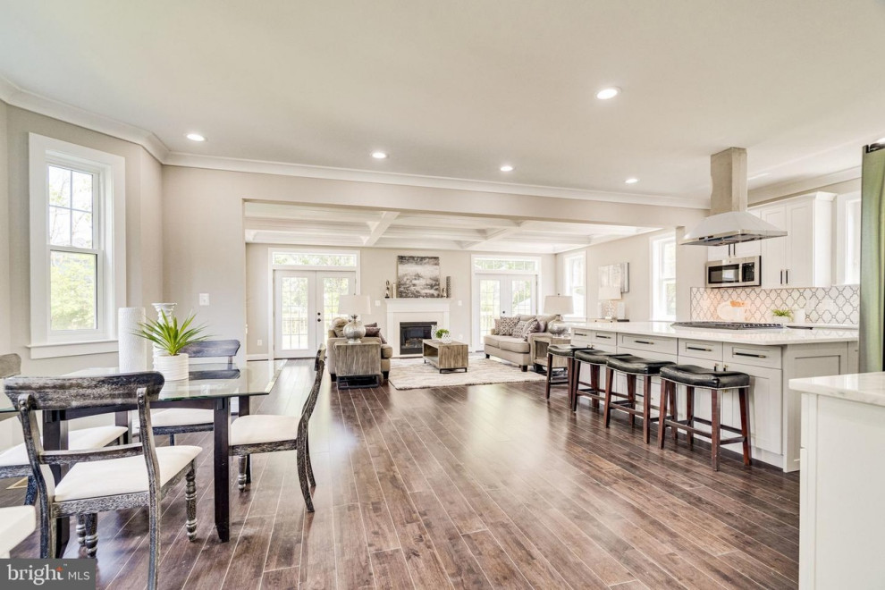 Design ideas for an expansive arts and crafts open plan dining in DC Metro with grey walls, dark hardwood floors, a standard fireplace, a wood fireplace surround, brown floor and coffered.