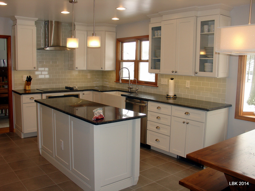 Mid-sized transitional l-shaped porcelain tile eat-in kitchen photo in Philadelphia with a farmhouse sink, shaker cabinets, white cabinets, wood countertops, green backsplash, subway tile backsplash, stainless steel appliances and an island