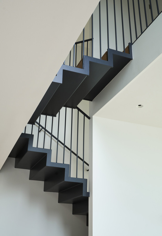 Idées déco pour un escalier moderne de taille moyenne avec des marches en bois et un garde-corps en métal.