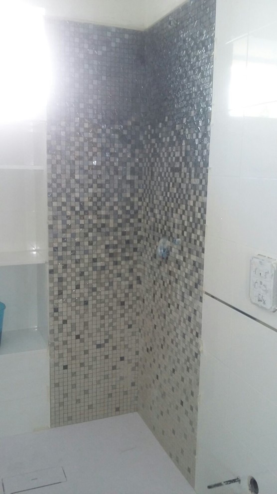 Photo of a modern 3/4 bathroom in Other with furniture-like cabinets, an open shower, a two-piece toilet, white tile, mosaic tile, white walls, porcelain floors and a drop-in sink.