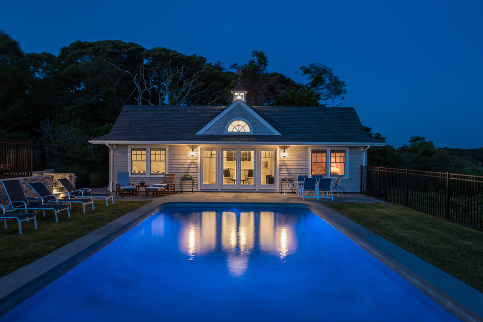 Beach style side yard rectangular pool in Boston with a pool house and natural stone pavers.