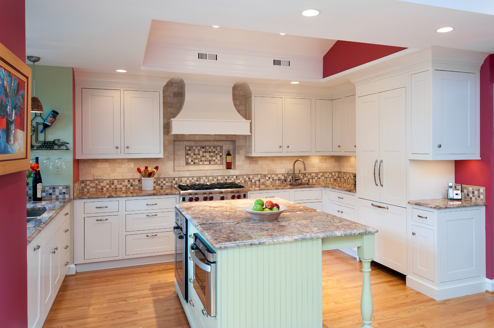 Inspiration for a mid-sized traditional u-shaped separate kitchen in DC Metro with shaker cabinets, a double-bowl sink, white cabinets, granite benchtops, beige splashback, porcelain splashback, stainless steel appliances, light hardwood floors, with island and beige floor.