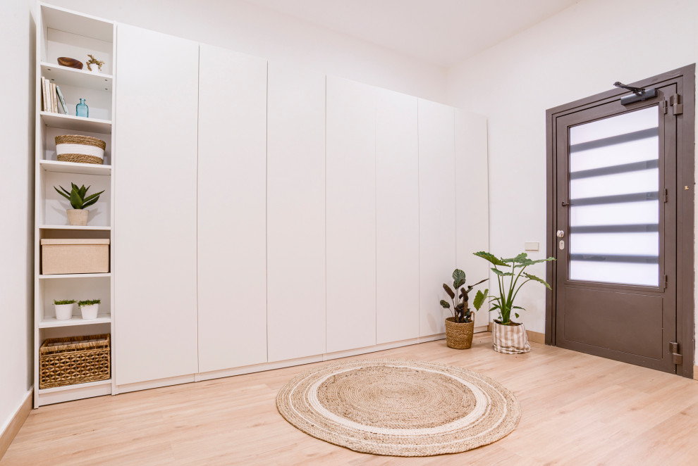 Example of a large mountain style light wood floor hallway design in Barcelona with white walls