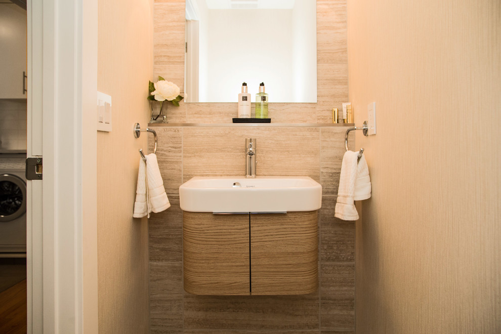 Photo of a small contemporary powder room in Calgary with a wall-mount sink, flat-panel cabinets and light wood cabinets.