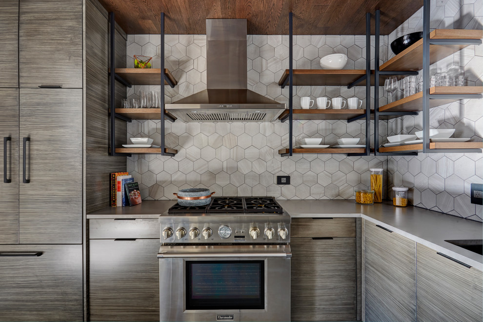 This is an example of a mid-sized industrial u-shaped kitchen pantry in Chicago with an undermount sink, flat-panel cabinets, grey cabinets, quartz benchtops, grey splashback, porcelain splashback, stainless steel appliances, medium hardwood floors, no island and grey floor.