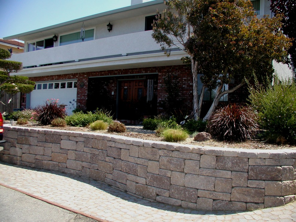 Inspiration for a mid-sized traditional front yard xeriscape in San Luis Obispo with a retaining wall and natural stone pavers.