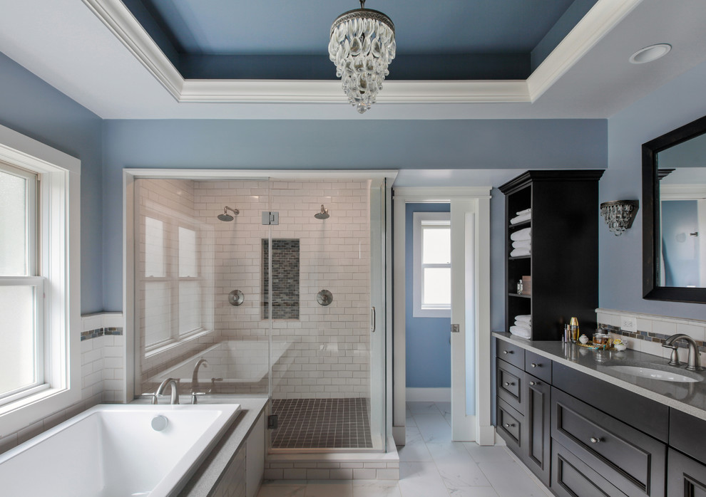 Example of a large transitional master white tile and subway tile ceramic tile corner shower design in DC Metro with an undermount sink, recessed-panel cabinets, dark wood cabinets, solid surface countertops, an undermount tub, a two-piece toilet and blue walls