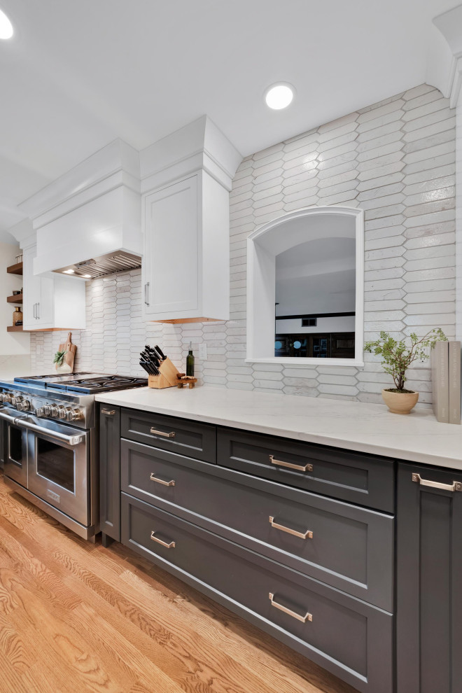 Inspiration for an expansive transitional l-shaped eat-in kitchen in Columbus with an undermount sink, grey cabinets, quartzite benchtops, white splashback, brick splashback, stainless steel appliances, light hardwood floors, with island, yellow floor and white benchtop.