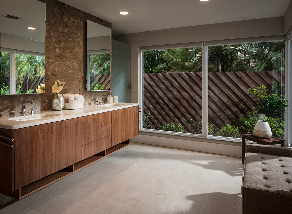 Photo of a mid-sized midcentury master bathroom in Miami with flat-panel cabinets, brown tile, stone slab, grey walls, porcelain floors, an undermount sink, marble benchtops, beige floor, beige benchtops and medium wood cabinets.