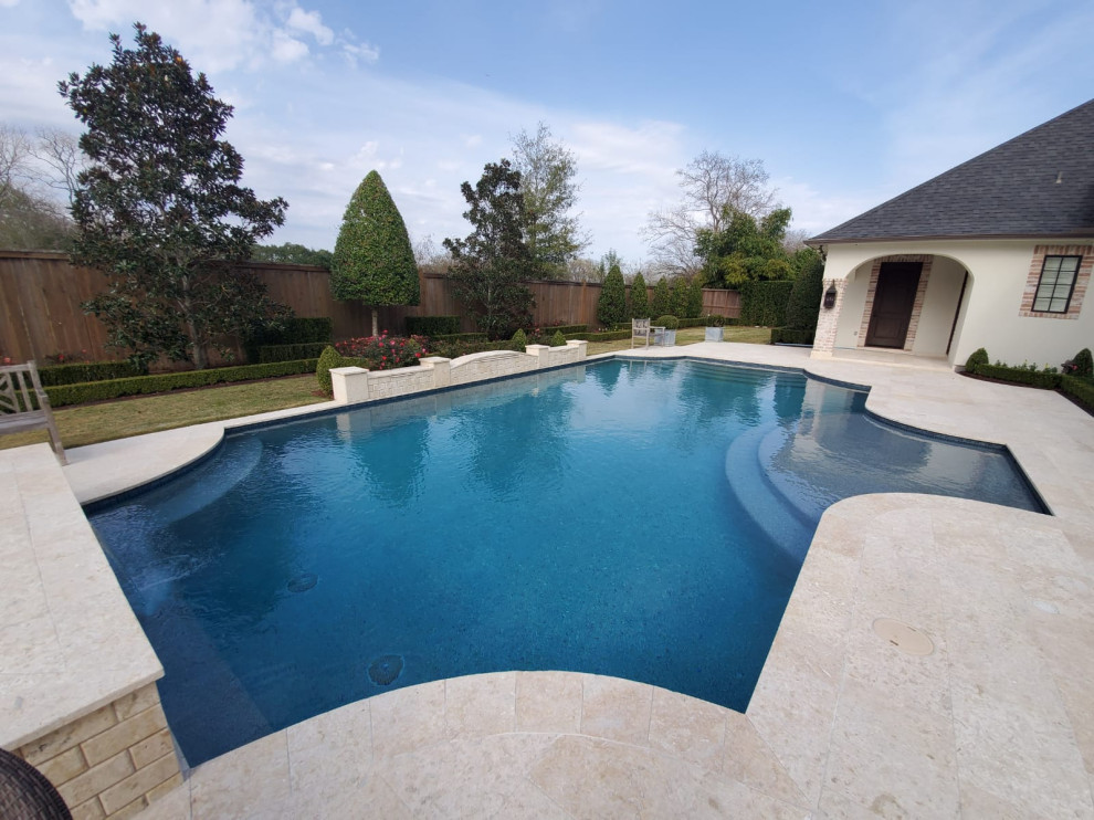 Design ideas for a mid-sized mediterranean backyard custom-shaped lap pool in Houston with a water feature and tile.