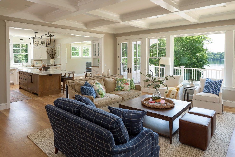 Inspiration for a large beach style open plan games room in Minneapolis with beige walls, light hardwood flooring, a standard fireplace, a stone fireplace surround, a concealed tv and a coffered ceiling.