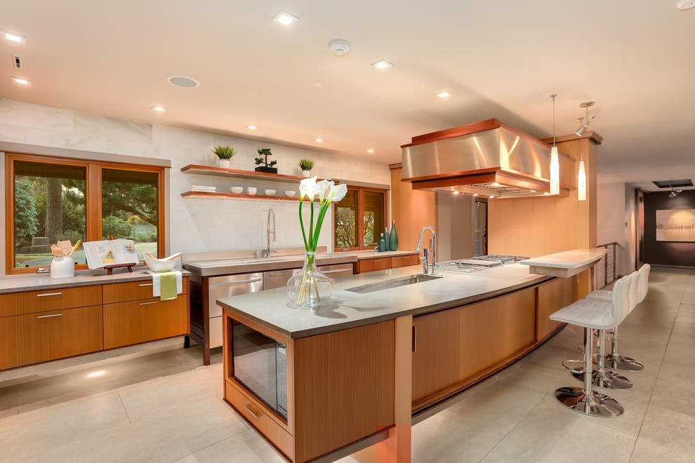 Contemporary kitchen in Seattle with an undermount sink, flat-panel cabinets, medium wood cabinets, white splashback, stainless steel appliances, a peninsula, grey benchtop and beige floor.