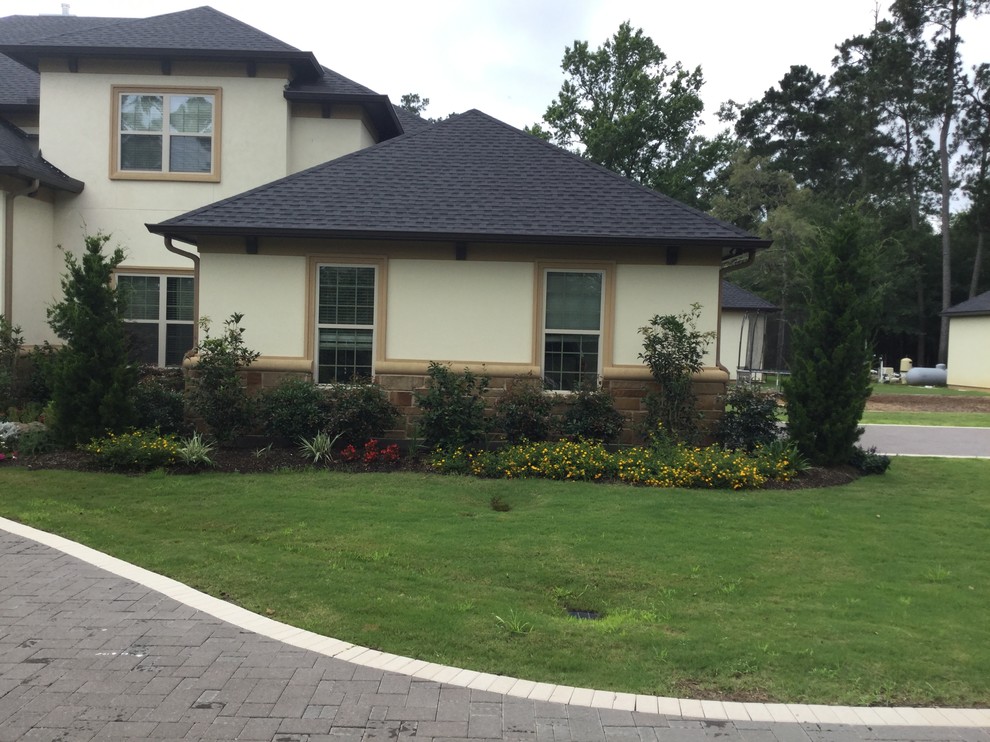 Photo of a large contemporary front yard driveway in Houston with a water feature and natural stone pavers.