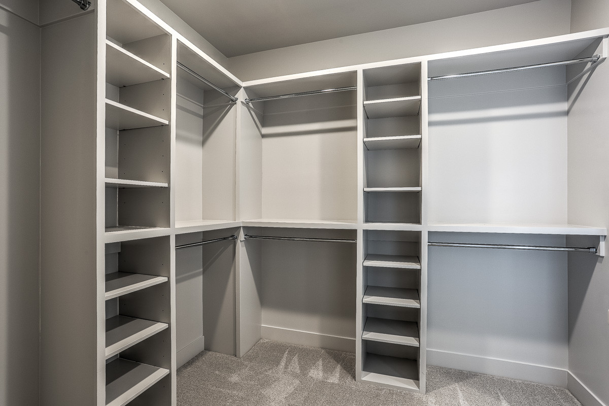 Inspiration for a cottage gender-neutral carpeted and gray floor walk-in closet remodel in Omaha