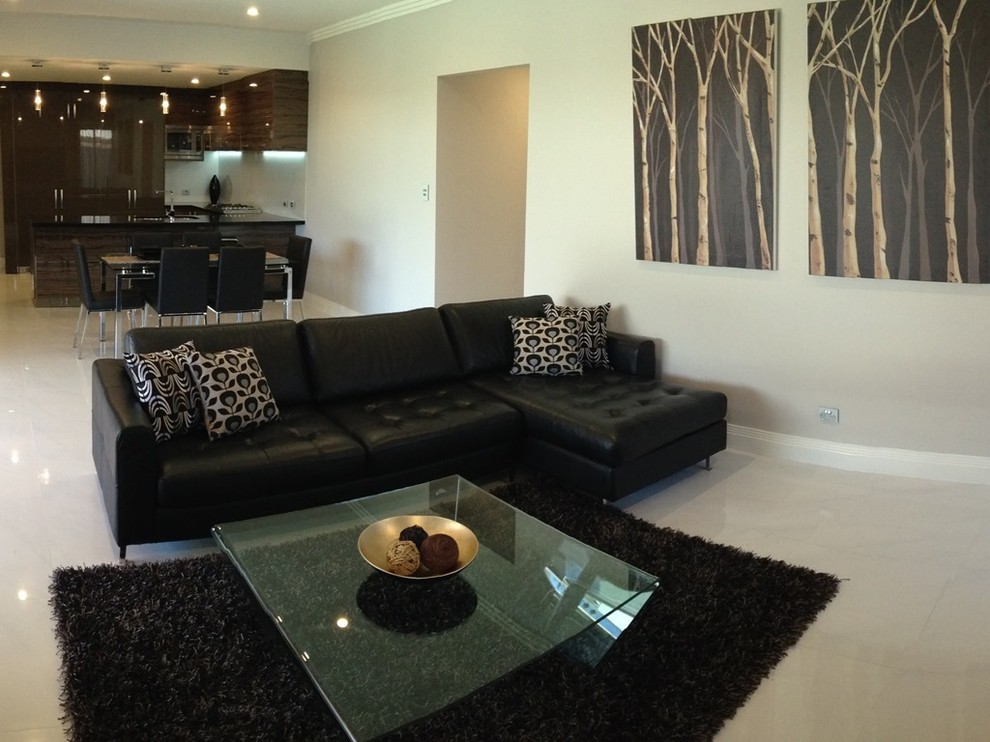 Large contemporary open concept family room in Perth with beige walls, ceramic floors, no fireplace and a freestanding tv.