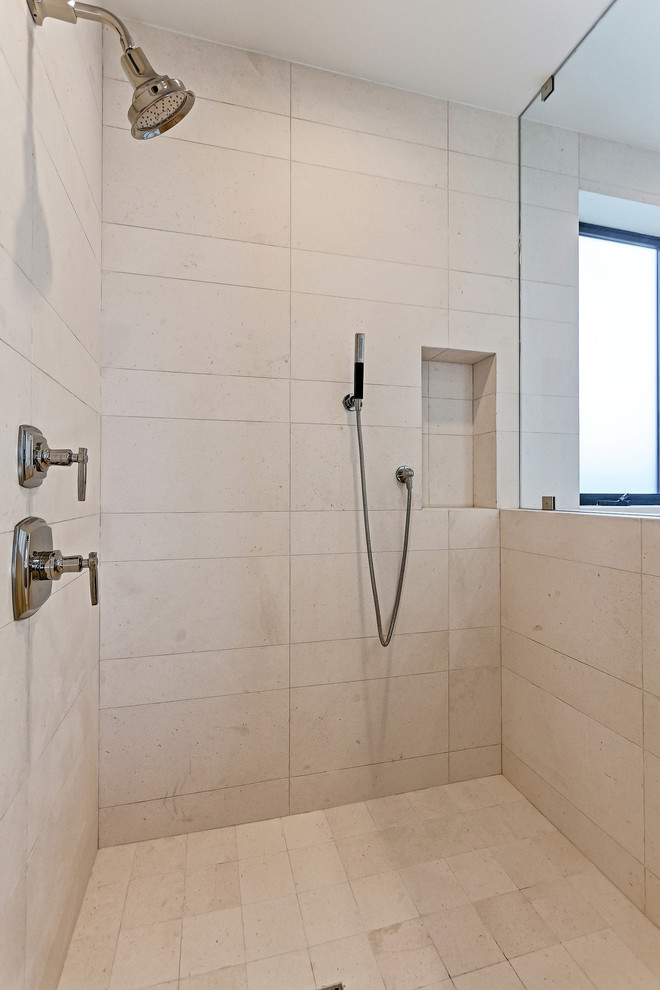 This is an example of a contemporary bathroom in Los Angeles with a corner shower, beige tile, marble, beige walls, marble floors, beige floor and a hinged shower door.